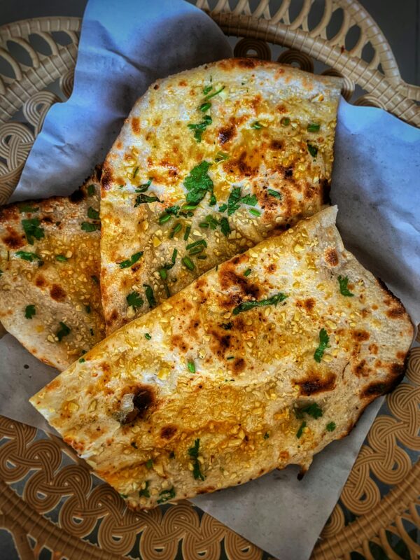 Delicious herbed flatbread with garlic and sesame seeds on a decorative tray.