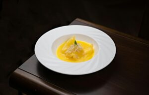 Delicious dessert elegantly presented in a white bowl with vibrant orange sauce, perfect for culinary presentations.